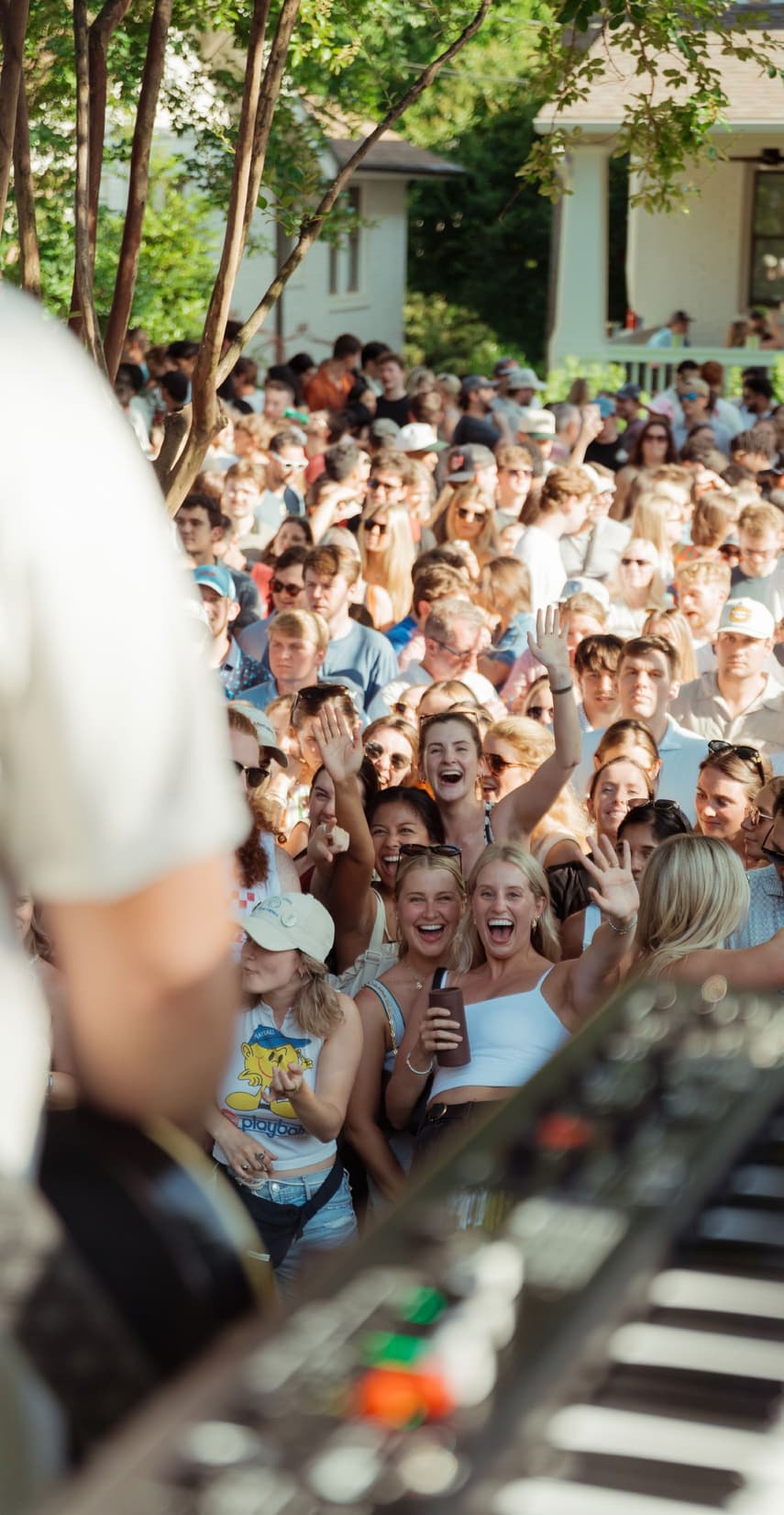 A crowd gathers around a Denver porch performance